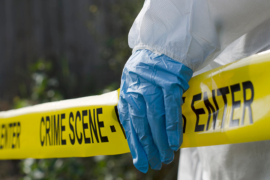 Hazmat cleanup team holding crime scene do not enter tape, preparing for homicide cleanup in Fairfax, VA