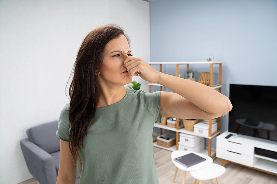 Woman plugging nose in need of odor removal in Alexandria, VA